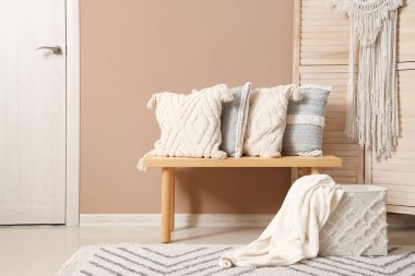 Odanın içi ahşap bankta şık yastıklarla dolu.