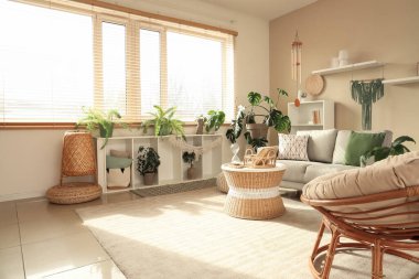 Rüzgar çanı, kanepe ve bitkilerle aydınlık oturma odasının içinde.