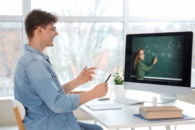 Erkek öğrenci evde online matematik okuyor.