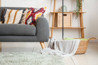 Oturma odasının içinde siyah kanepe, sehpa ve minderler var.