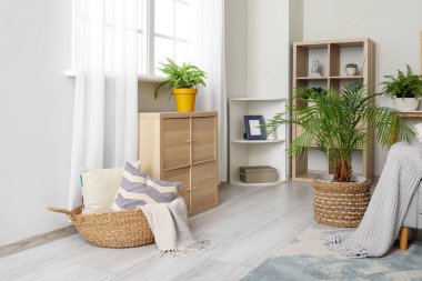 Oturma odasında yastıklı, ekoseli ve çekmeceli bir kanepe.