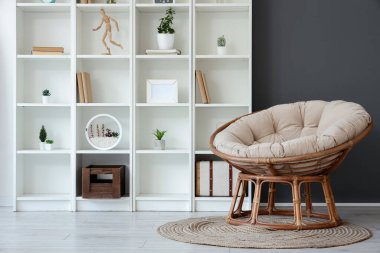 Rahat koltuğu ve raf ünitesi olan modern oturma odası.