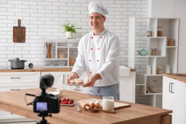 Kekli erkek aşçı mutfakta yemek pişirme videosu çekiyor.