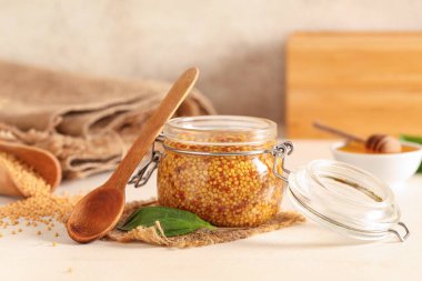 Dijon hardallı kavanoz ve bej kaplamalı fesleğen.