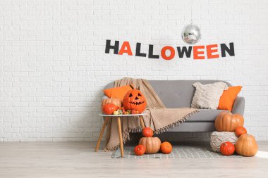 Cadılar Bayramı partisi için dekore edilmiş kanepe, balkabağı ve disko topu olan şık bir oda.