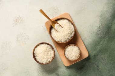 Çiğ pirinçli ahşap kaseler ve grunge arka planda kepçe