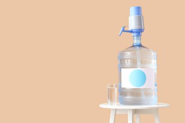 Bej arka planda cam kaplı bir şişe temiz su.