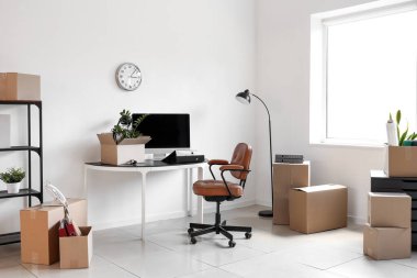 Taşınma gününde iş yeri, lamba ve karton kutuların olduğu ofis içi
