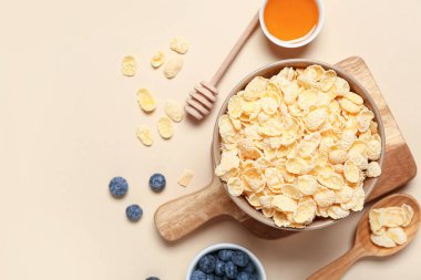 Bej arka planda lezzetli mısır gevreği, yabanmersini ve bal içeren kompozisyon