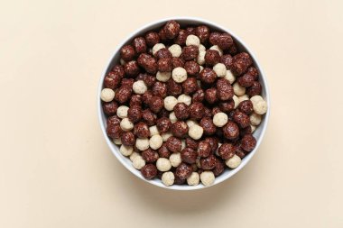 Bej arka planda çikolatalı mısır topları olan kase, yakın plan.