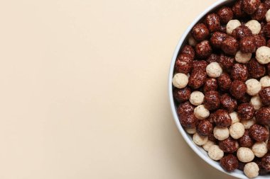 Bej arka planda çikolatalı mısır topları olan kase, yakın plan.