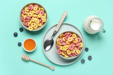 Lezzetli renkte mısır gevreği halkaları ve turkuaz arka planda bal içeren kompozisyon