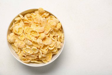 Beyaz arka planda lezzetli mısır gevrekleri olan kase, yakın plan.