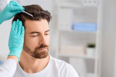 Klinikte muayene eden doktor. Saç dökülme problemi