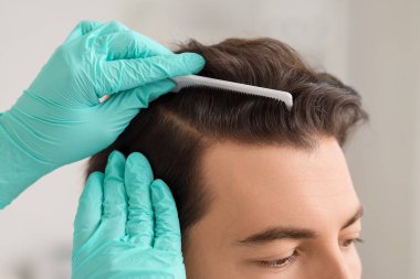 Klinikte muayene yapan doktor, yakın plan. Saç dökülme problemi