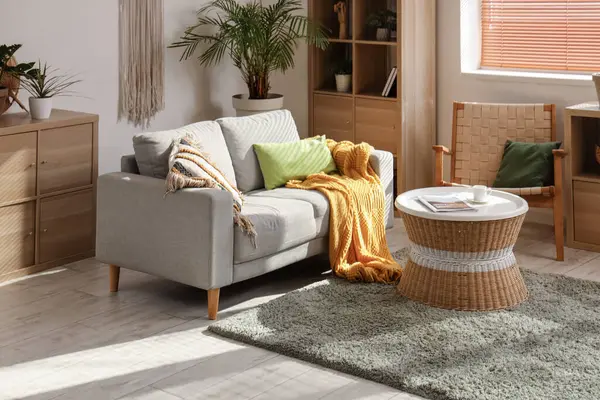 Kanepesi, sehpası, yastıkları ve çiçekleri olan güzel bir oturma odası.