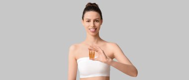 Hafif arka planda ampulleri olan güzel bir genç kadın. Kozmetoloji kavramı