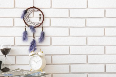 Odadaki beyaz tuğla duvarda asılı düş kapanı