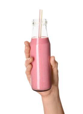 Beyaz arka planda cam şişe pembe smoothie ile kadın eli.