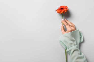 Işıklı arka planda çiçekli bir kadın. El bakımı kavramı