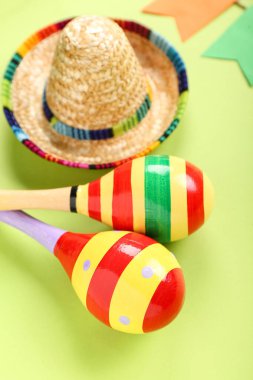 Yeşil arka planda şapkası olan Meksika marakaları, yakın plan.