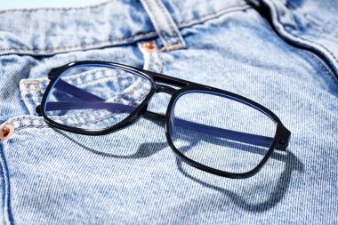 Arka plan olarak siyah gözlüklü şık kot, yakın plan