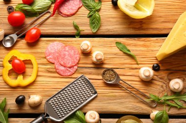 Tahta arka planda pizza hazırlamak için gerekli malzemeler