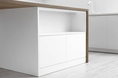 Mutfakta çekmeceleri olan beyaz bir tezgah.