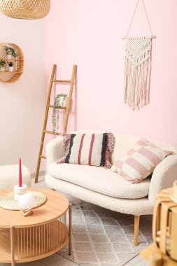 Beyaz kanepe, kahve masası ve sehpası olan bir oturma odası.