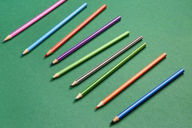 Yeşil karatahta üzerinde renkli kalemler grubu