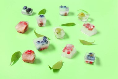 Buz küplerinde donmuş böğürtlen ve yeşil arka planda yapraklar