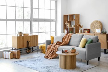 Gri kanepe ve çekmeceleri olan oturma odasının içinde.