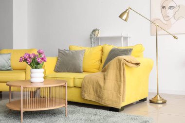 Oturma odasındaki masada pembe laleli vazo.