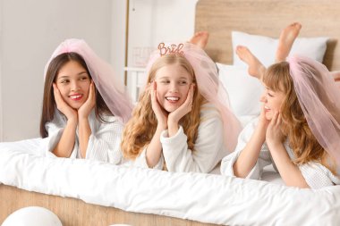Genç kadın ve nedimeleri Hen Party 'de yatakta yatıyorlar.