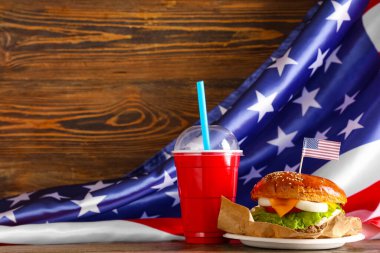 Lezzetli burger, kola ve ahşap masada Amerikan bayrağı. Amerikan Bağımsızlık Günü kutlamaları