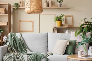 Yeşil çiçekleri ve kanepesi olan şık bir oda.