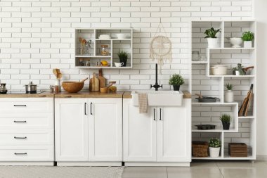 Mutfağın içinde farklı tabaklar ve tezgahlar var.