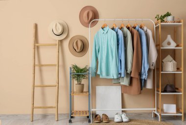 Giysi askısı, merdiven ve rafları bej duvarın yanında olan modern soyunma odasının içinde.