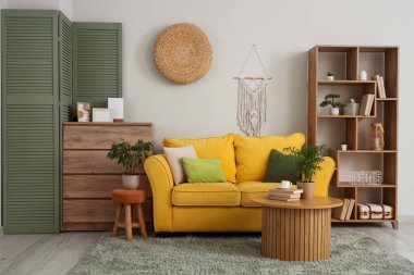 Sarı kanepe ve sehpası olan oturma odasının içinde.