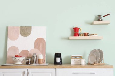 Mutfağın içinde tezgah, kahve makinesi ve resim makinesi var.