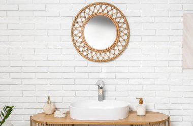 Lavabo sabun ve aynayla beyaz tuğla duvarda tuvalette.