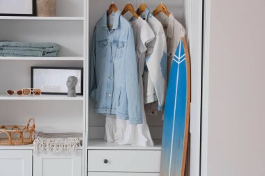 Sörf tahtası ve dolabı olan bir ışık odası.