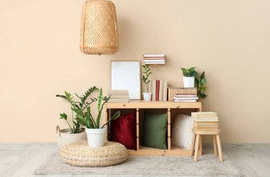 Odanın içinde bitkiler, kitaplar ve boş çerçeveler var.