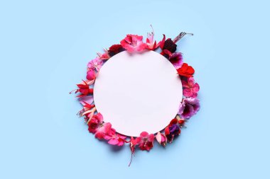 Mavi arka planda farklı güzel, yenilebilir çiçekleri olan boş bir kart.