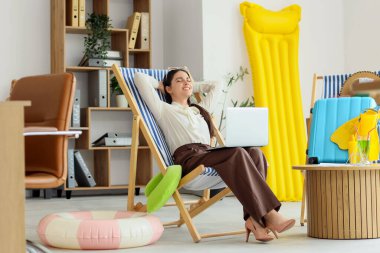 Tatilden önce ofiste dinlenen mutlu iş kadını.