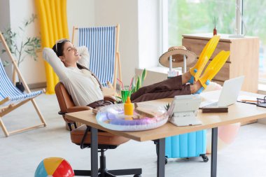 Tatilden önce ofiste dinlenen mutlu iş kadını.