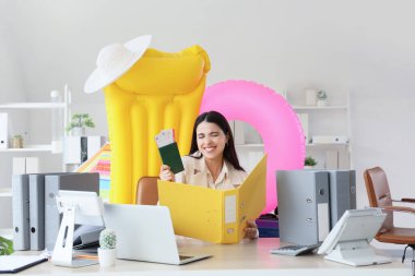 Tatilden önce plaj aksesuarları, pasaport ve biletleri olan mutlu iş kadını.