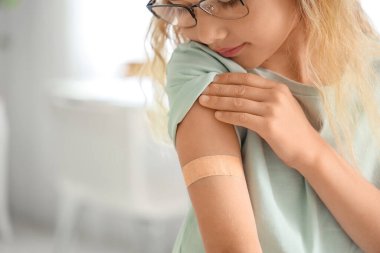 Klinikte aşıdan sonra tıbbî tedavi gören küçük kız, yakın plan.