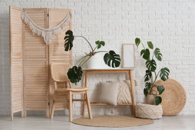 İçinde Monstera bitkileri, masa ve sandalye olan bir oturma odası.