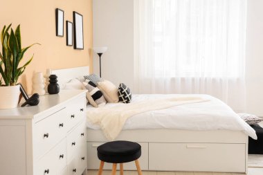 İçinde yatak, tuvalet ve lamba olan şık bir oda.